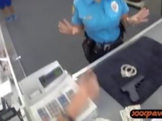 Zonjë polic oficer merr gozhdohem në një pawnshop në fitoj para në dorë